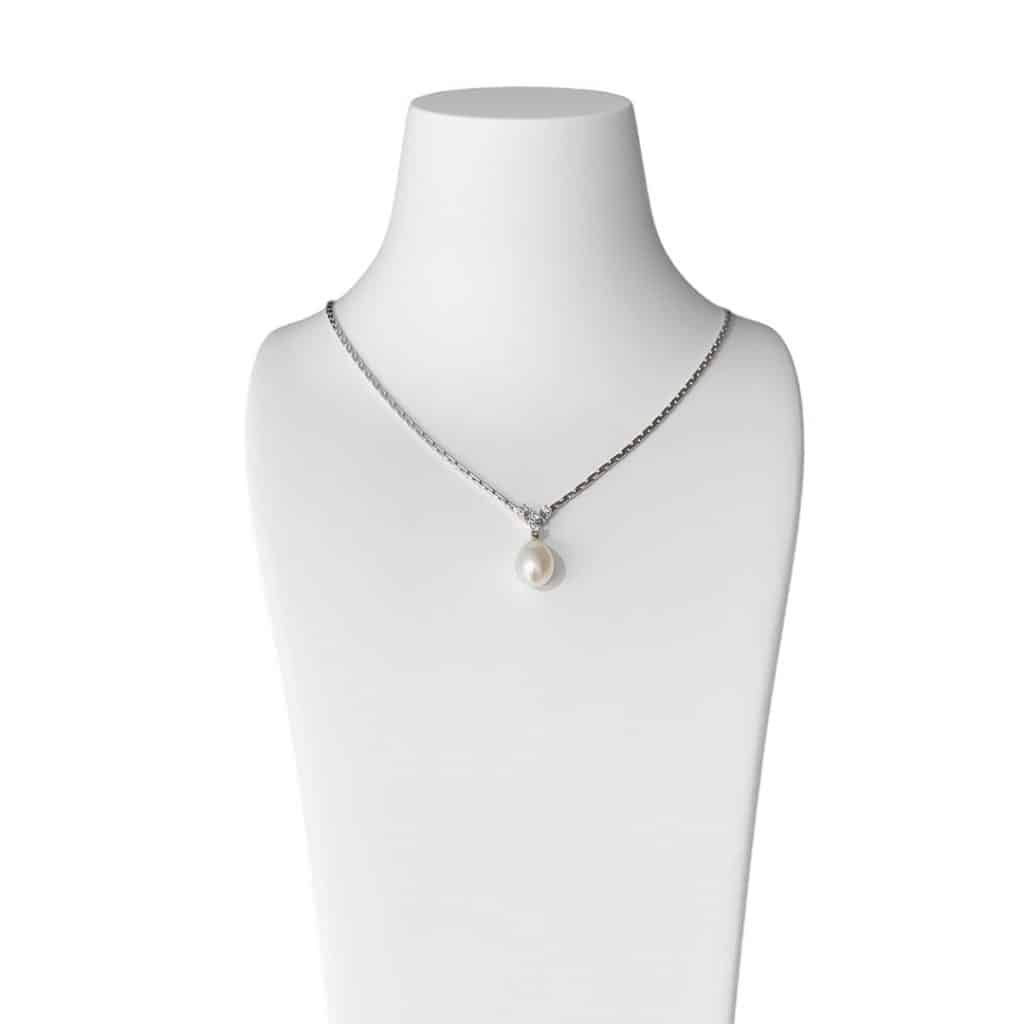 Elegantes Perlencollier mit tropfenförmiger Perle und zarten Zirkonia, präsentiert auf einer Schmuckbüste.