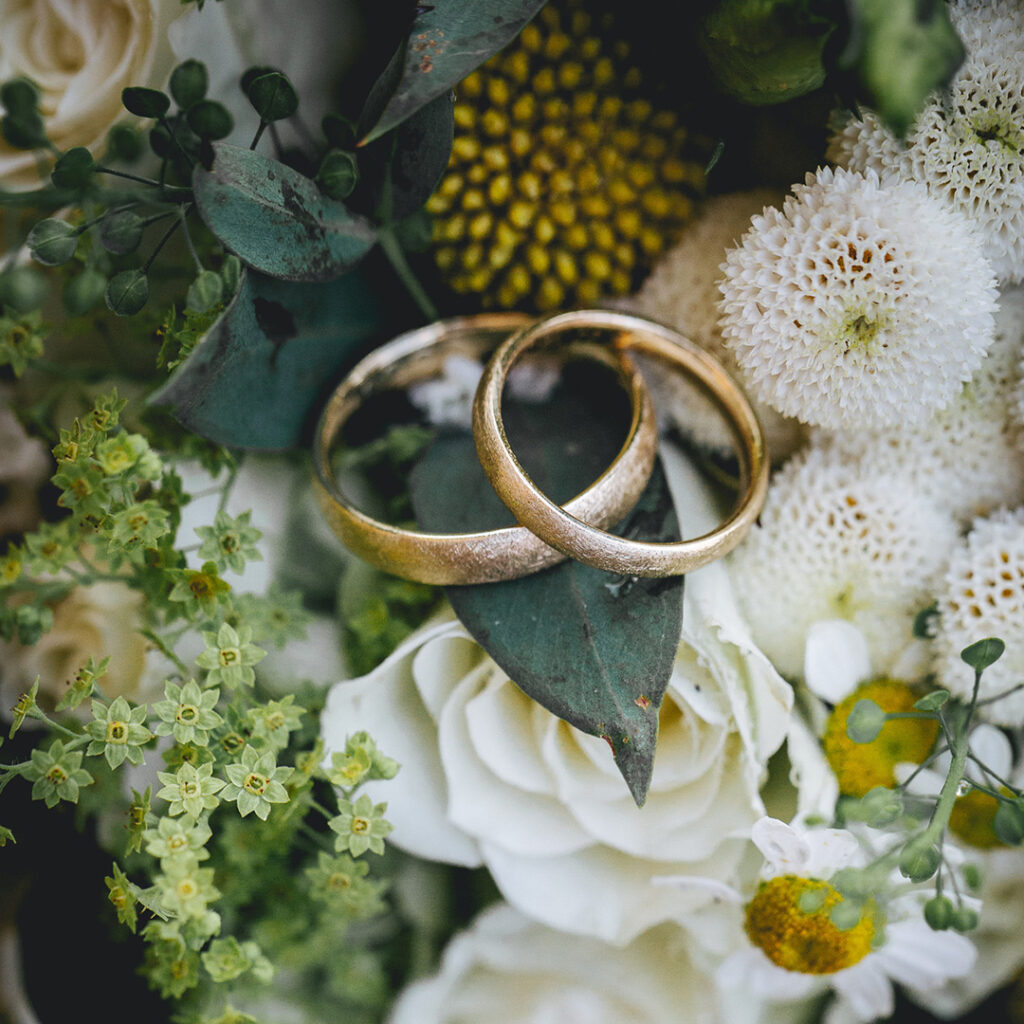 Eheringe liegen schön platziert auf Blumen